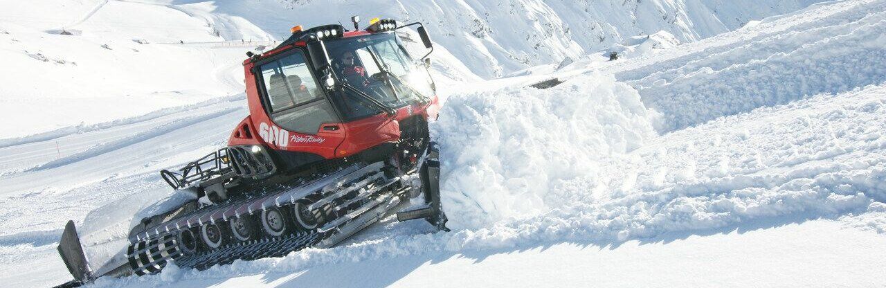 PistenBully schiebt Schnee den Berg hoch 